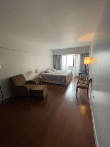 a hotel room with a bed and a chair at Hotel Sol Alphaville in Barueri