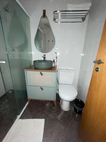 a bathroom with a toilet and a sink and a mirror at Hotel Sol Alphaville in Barueri