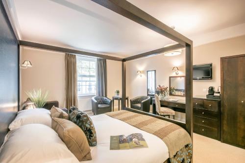 a hotel room with a bed and a desk at Forest Lodge Hotel in Lyndhurst