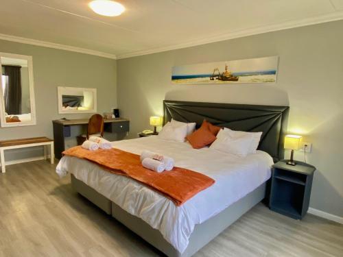 a bedroom with a large bed with two stuffed animals on it at Ngandu at Sea in Meersig