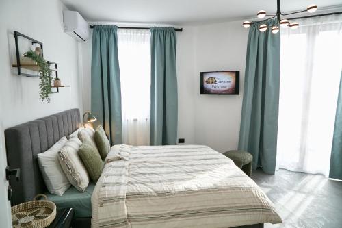 a bedroom with a bed and a couch and windows at Gatev House in Teteven