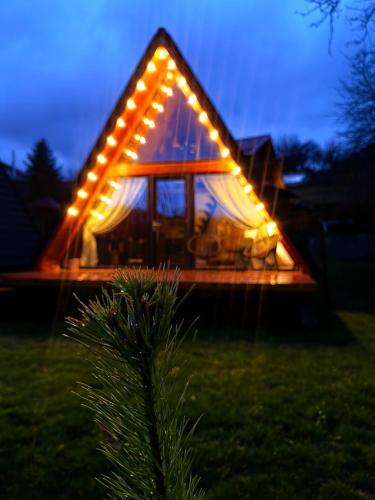 a small house with lights on the front of it at MooN by Sun&Moon Cabins in Măneciu