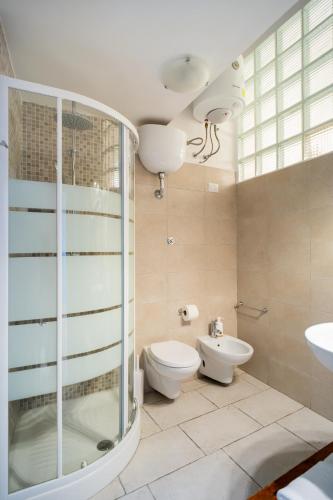 a bathroom with a toilet and a glass shower at Il Da Vinci Apartment in Giovinazzo