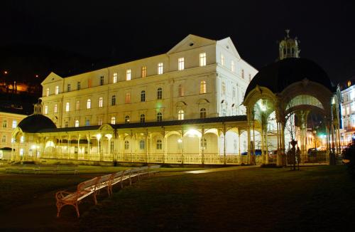 a large building with a bench in front of it at Lázeňský Hotel Sadový Pramen in Karlovy Vary