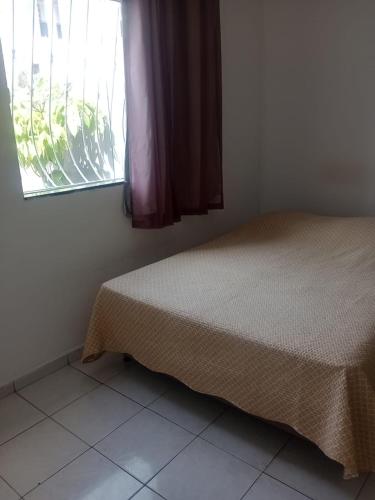 a bed in a room with a window at Casa Wense - prox a praia in Ilhéus