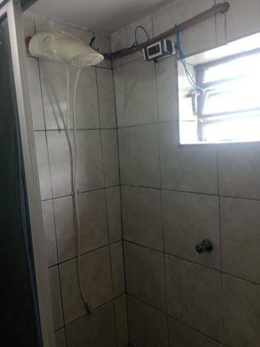 a shower with a shower head in a bathroom at Casa Wense - prox a praia in Ilhéus