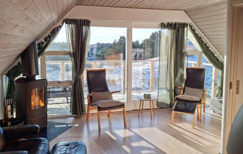 a living room with two chairs and a fireplace at 4 Bedroom Stunning Home In Fanø in Fanø
