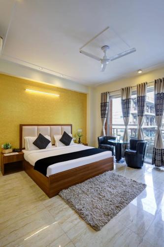 a bedroom with a bed and a living room at Hotel The Luxe 18 - Golf Course Road in Gurgaon