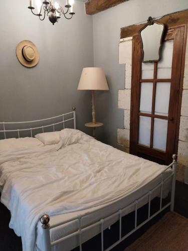 a bedroom with a bed and a lamp and a window at Studio cosy au calme in Chillac