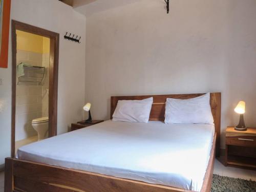 a bedroom with a large bed and a bathroom at Case Africaine Confort Terrasse Accès Plage in Mbour