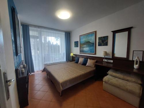a bedroom with a bed and a large window at Holiday Art Garden&Spa in Balatonfüred