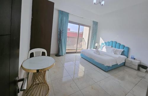a bedroom with a blue bed and a table at Golden Homes 2 in Dubai