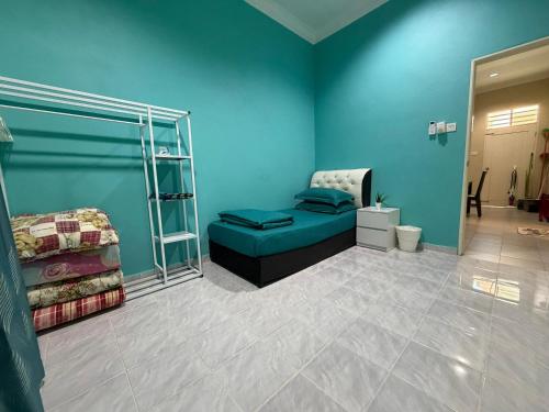 a room with a bed and a blue wall at Villa Dr Din in Rantau Panjang
