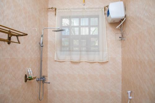 a shower in a bathroom with a window at Arusha Oasis Executive Residence in Arusha