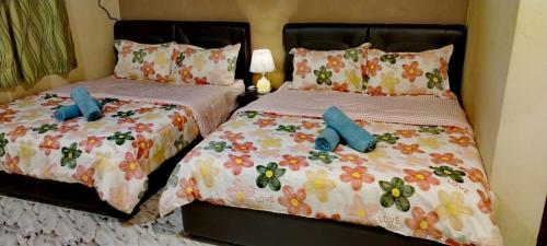 two beds in a bedroom with two blue pillows at 4F Motel and Homestay by LTS in Pantai Cenang