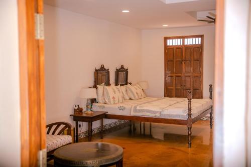 a bedroom with a bed and a table in a room at Krsna Farm Villa in Bangalore