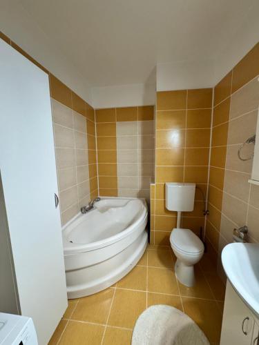 a bathroom with a tub and a toilet and a sink at Class Belvedere Apartments in Oradea