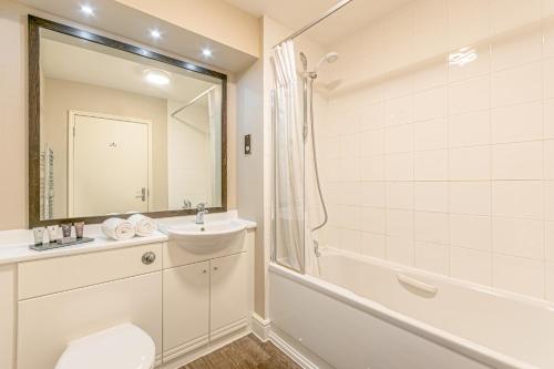 a bathroom with a toilet and a sink and a shower at Forest Lodge Hotel in Lyndhurst
