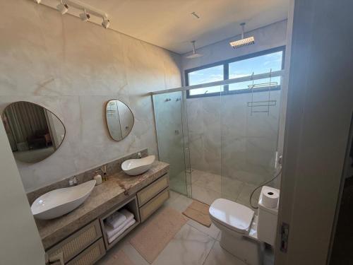 a bathroom with two sinks and a glass shower at Casa riviera in Aquiraz