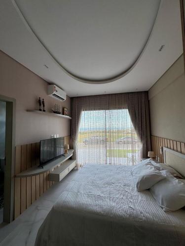 a bedroom with a large bed with a large window at Casa riviera in Aquiraz