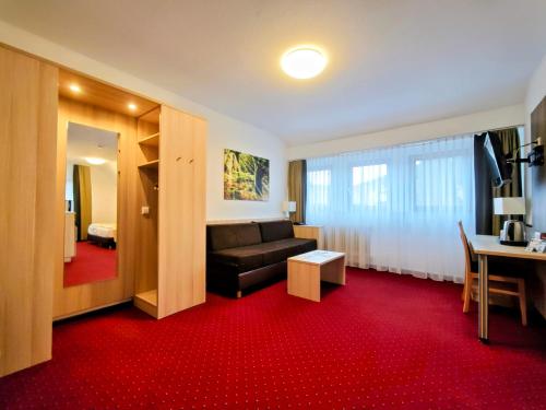 a living room with a couch and a red carpet at Wellness Hotel Garni Krone in Baiersbronn