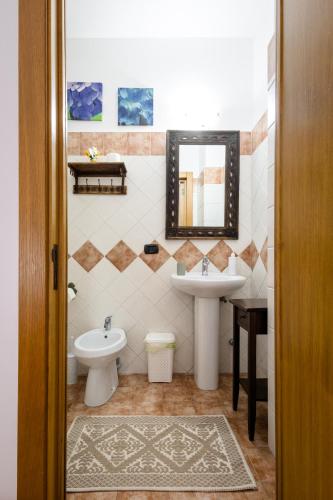 a bathroom with a sink and a toilet and a mirror at B&B Il Sedile in Lecce