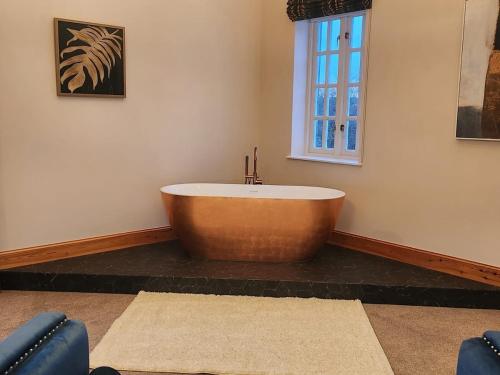 a large wooden tub in a room with a window at Recently refurbished former art studio in Rothiemay Station