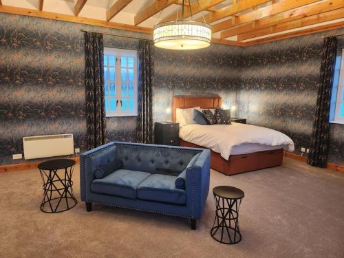 a bedroom with a bed and a blue couch at Recently refurbished former art studio in Rothiemay Station
