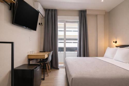 a hotel room with a bed and a desk and a television at New Amaryllis Hotel in Athens