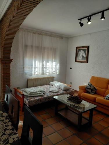 a living room with a bed and a table at Casa Rural El Hollejo in Pulgar