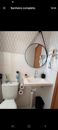 a bathroom with a sink and a toilet and a mirror at Apartamento Próximo Arena pantanal in Cuiabá