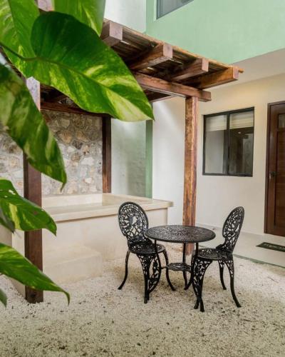 a patio with two chairs and a table and a tub at Esencia Valladolid Hotel in Valladolid