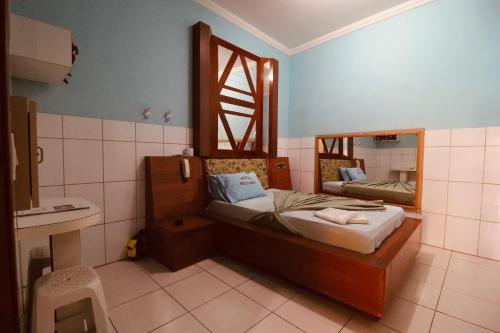 a small bedroom with a bed and a mirror at Hotel Bellamy in São Paulo