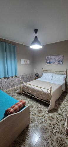 a bedroom with two beds and a blue curtain at Stella Marina Bed and Breakfast sul mare in Realmonte