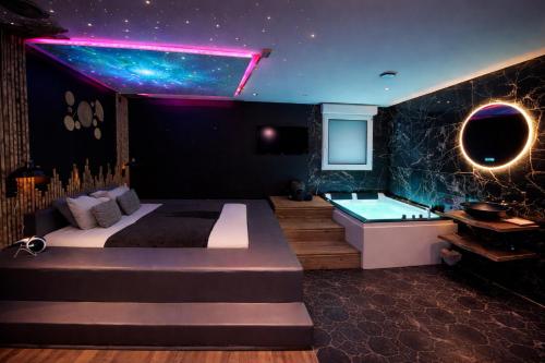 a bedroom with a bed and a bath tub at Suite Spa Sauna - Charleville - UNE PARENTHESE ARDENNAISE in Charleville-Mézières