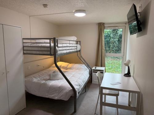 a small room with a bunk bed and a desk at Mot Hotel in Claye-Souilly