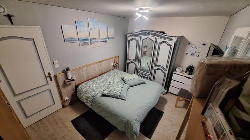 a small bedroom with a bed and a dresser at l'écureuil roux in Motteville
