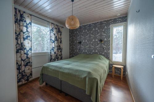 a bedroom with a bed and two windows at Villa Luoto A Stylish semi-detached house Incl AC, Sauna, Terrace in Kalajoki