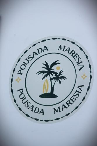 a label for a marina with a palm tree at Pousada Maresia in Guajiru