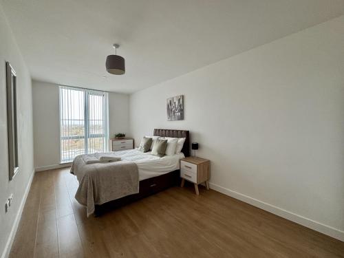 a white bedroom with a bed and a window at Bracknell RWH Spectacular Two Bedroom Apartment in Bracknell