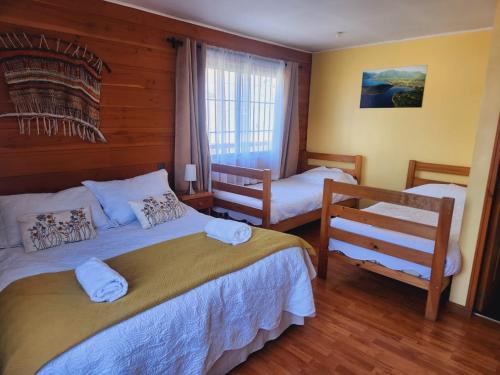 a bedroom with two beds and a window at Hotel Kernayel in Pucón