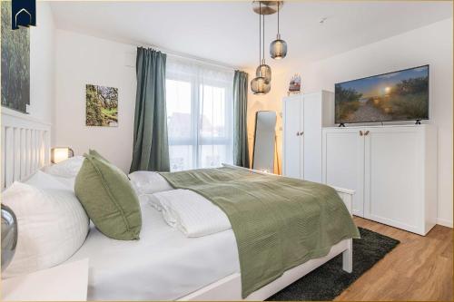 a bedroom with a white bed and a window at Ostseebude in Loddin