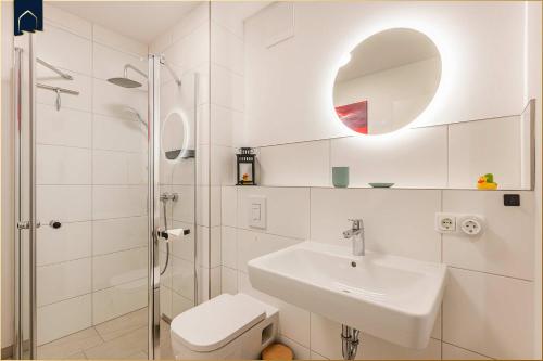 a white bathroom with a sink and a shower at Ostseebude in Loddin