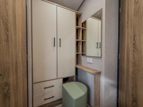 a small bathroom with a toilet and a mirror at Oakmont Lodge in Allerthorpe