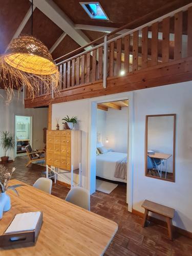 a room with a bed and a table and a bedroom at Alba Odeceixe - casa blanca in Odeceixe