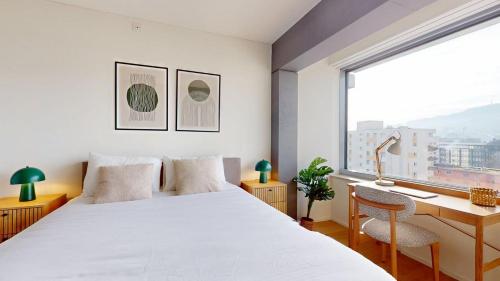 a bedroom with a bed and a desk and a window at Alto-Tower Residence - Self Check In in Zurich