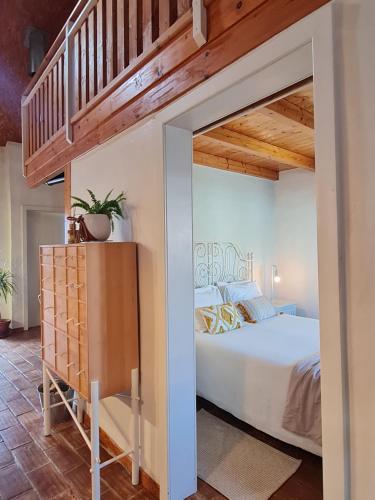 a bedroom with a large bed and a staircase at Alba Odeceixe - casa blanca in Odeceixe