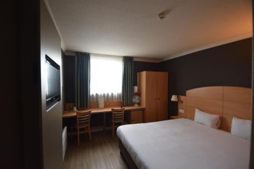 a hotel room with a bed and a desk at DC Sleep & Go Brussels West in Brussels