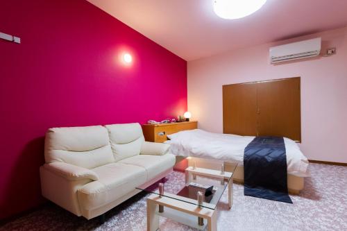 ein Wohnzimmer mit Sofa und Bett in der Unterkunft HOTEL Fiore Nakagawa -Adult Only- LOVE HOTEL in Nagoya