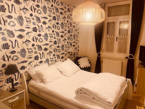a bedroom with a bed with a patterned wall at Au Cœur d Etaples in Étaples
